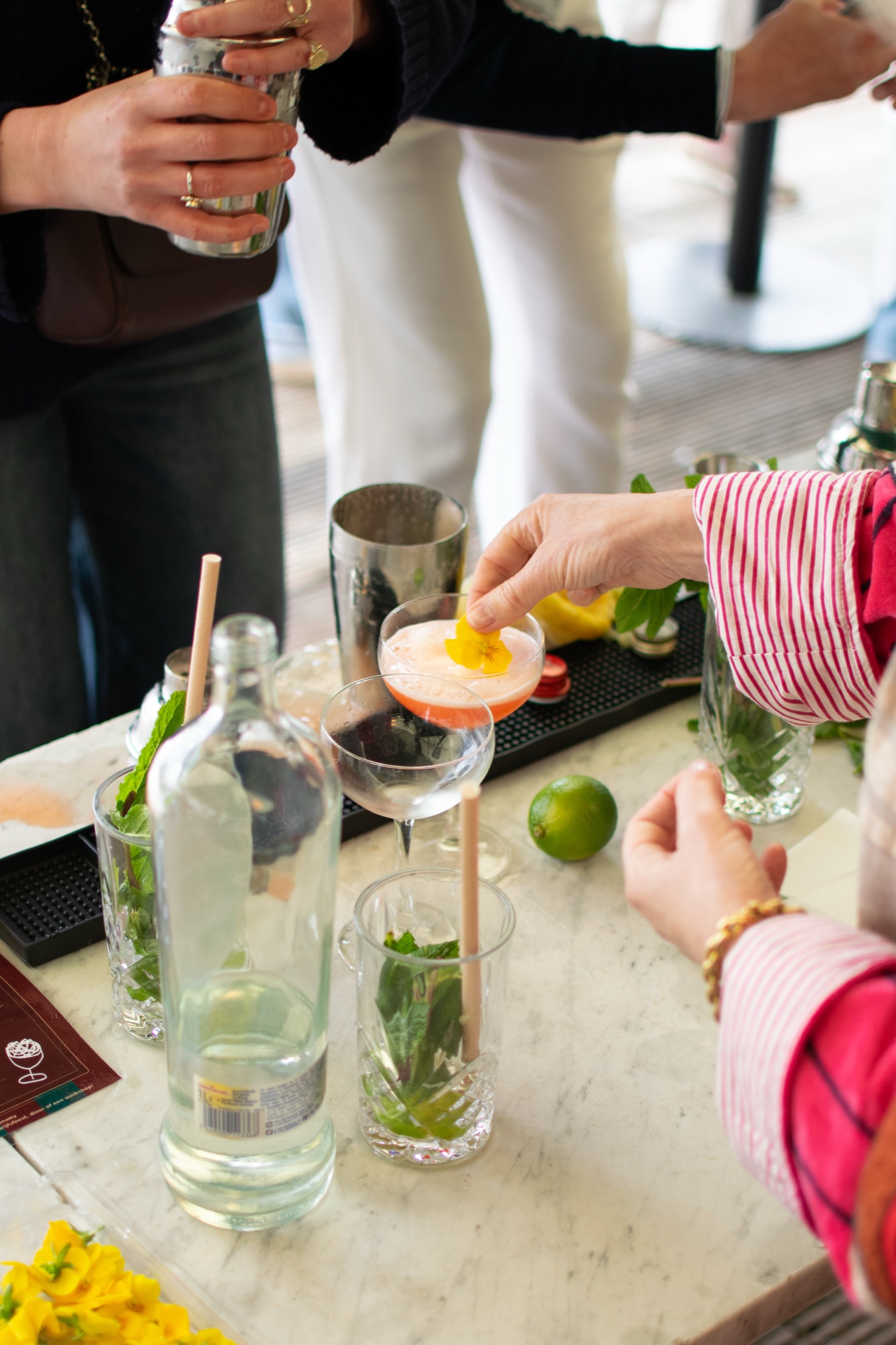 Twee gasten heffen samen een cocktail met bloemgarnering