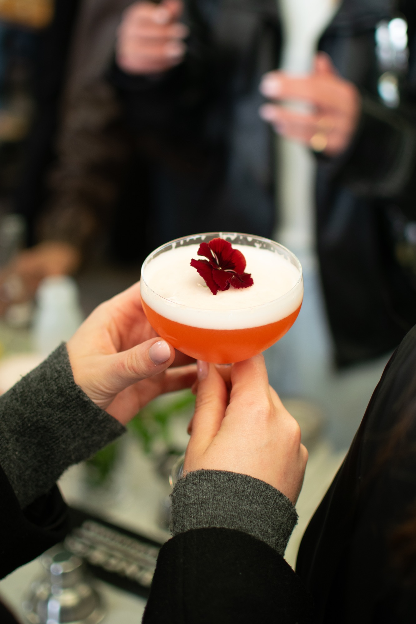 Close-up van een cocktail met rode bloemgarnering