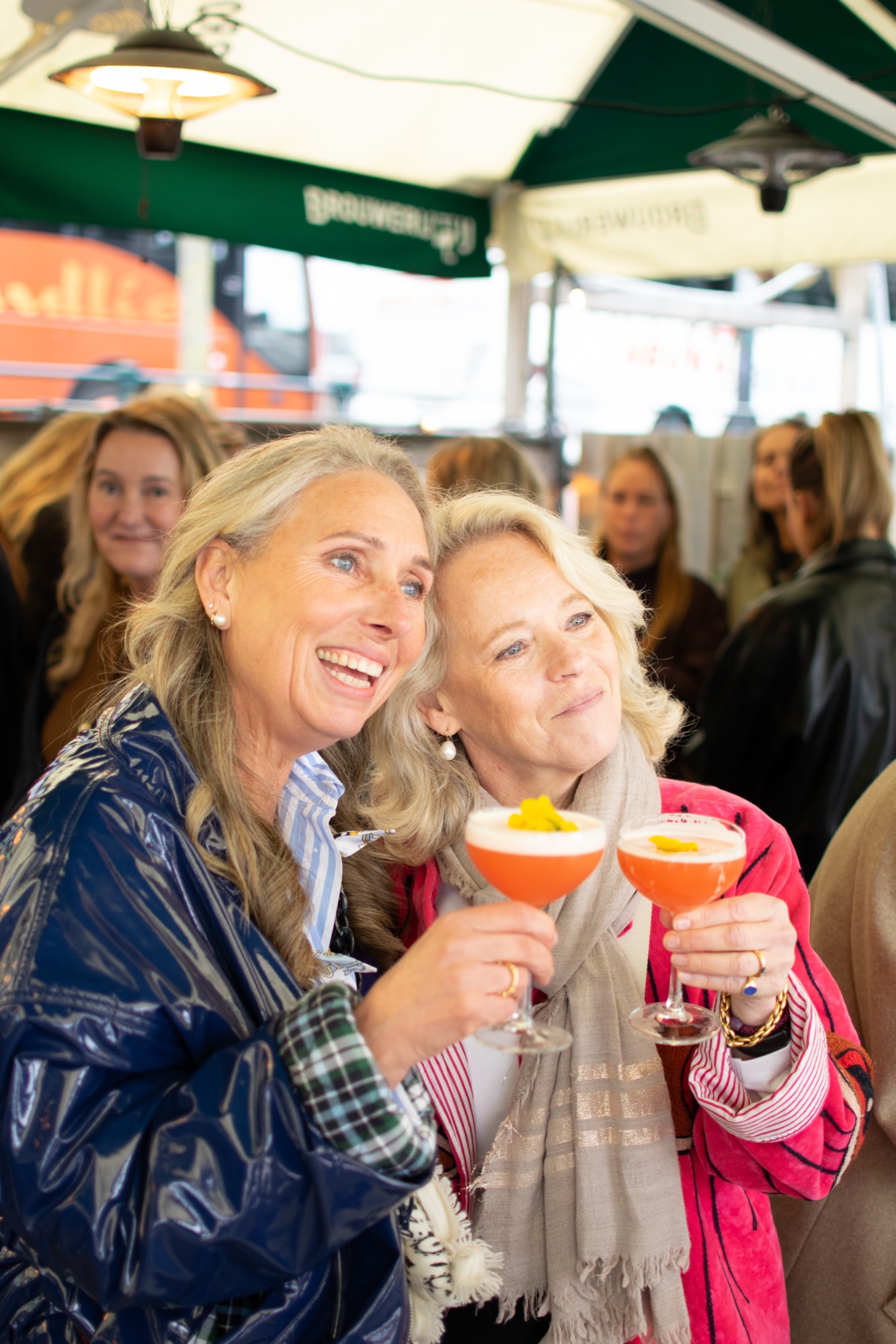 Twee gasten proosten met oranje cocktails
