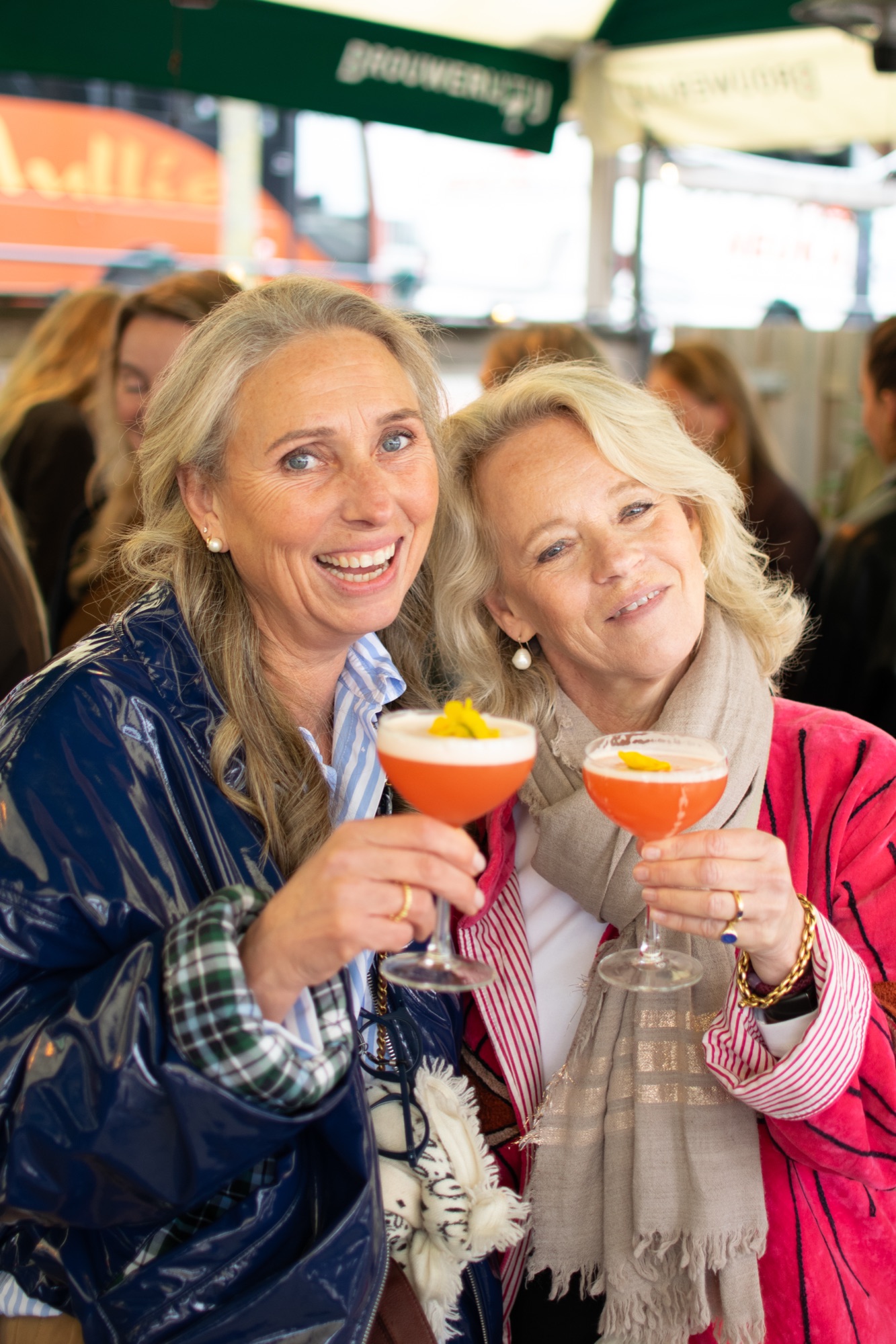 Twee gasten proosten met oranje cocktails