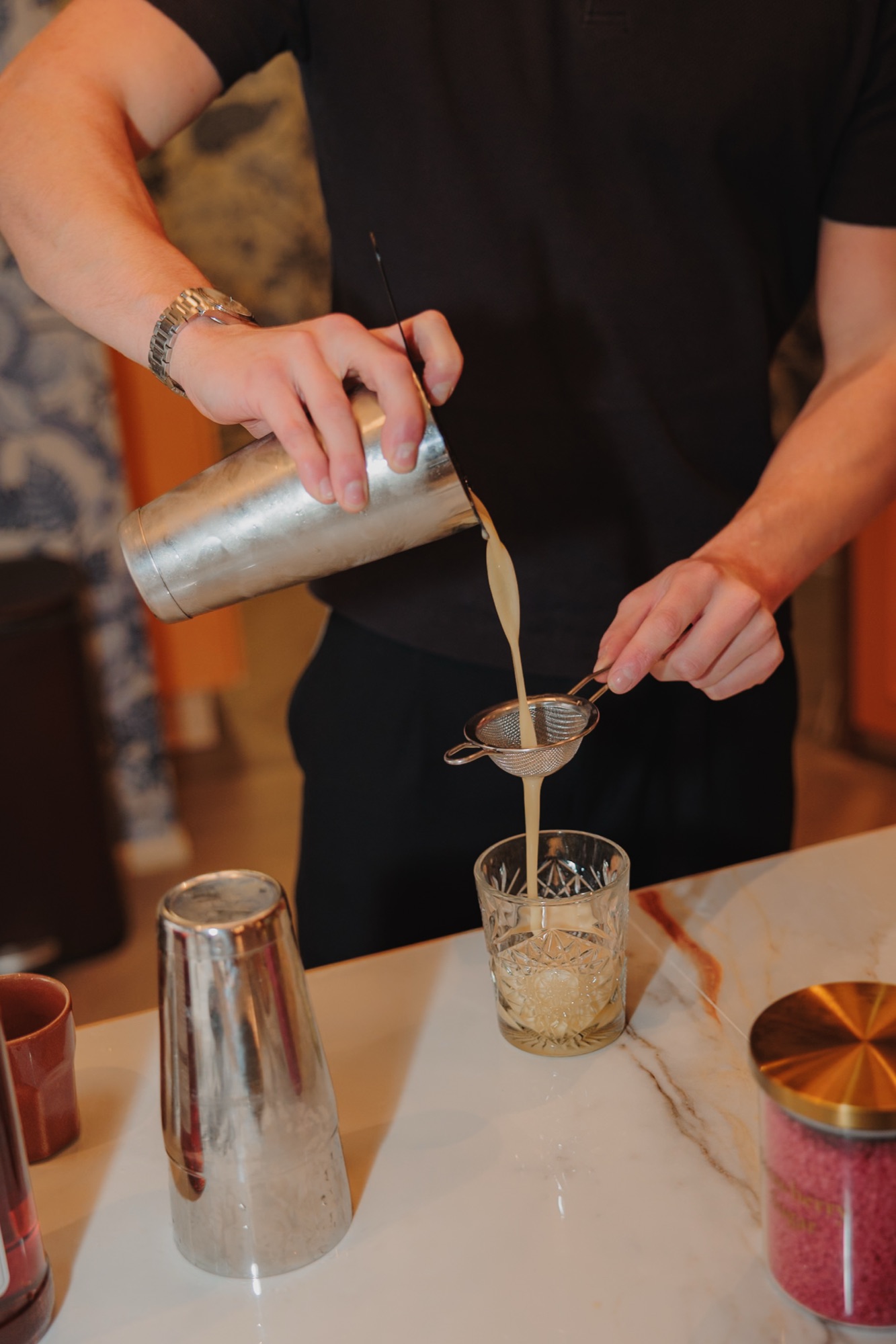 Cocktail wordt gezeefd in een glas tijdens de workshop