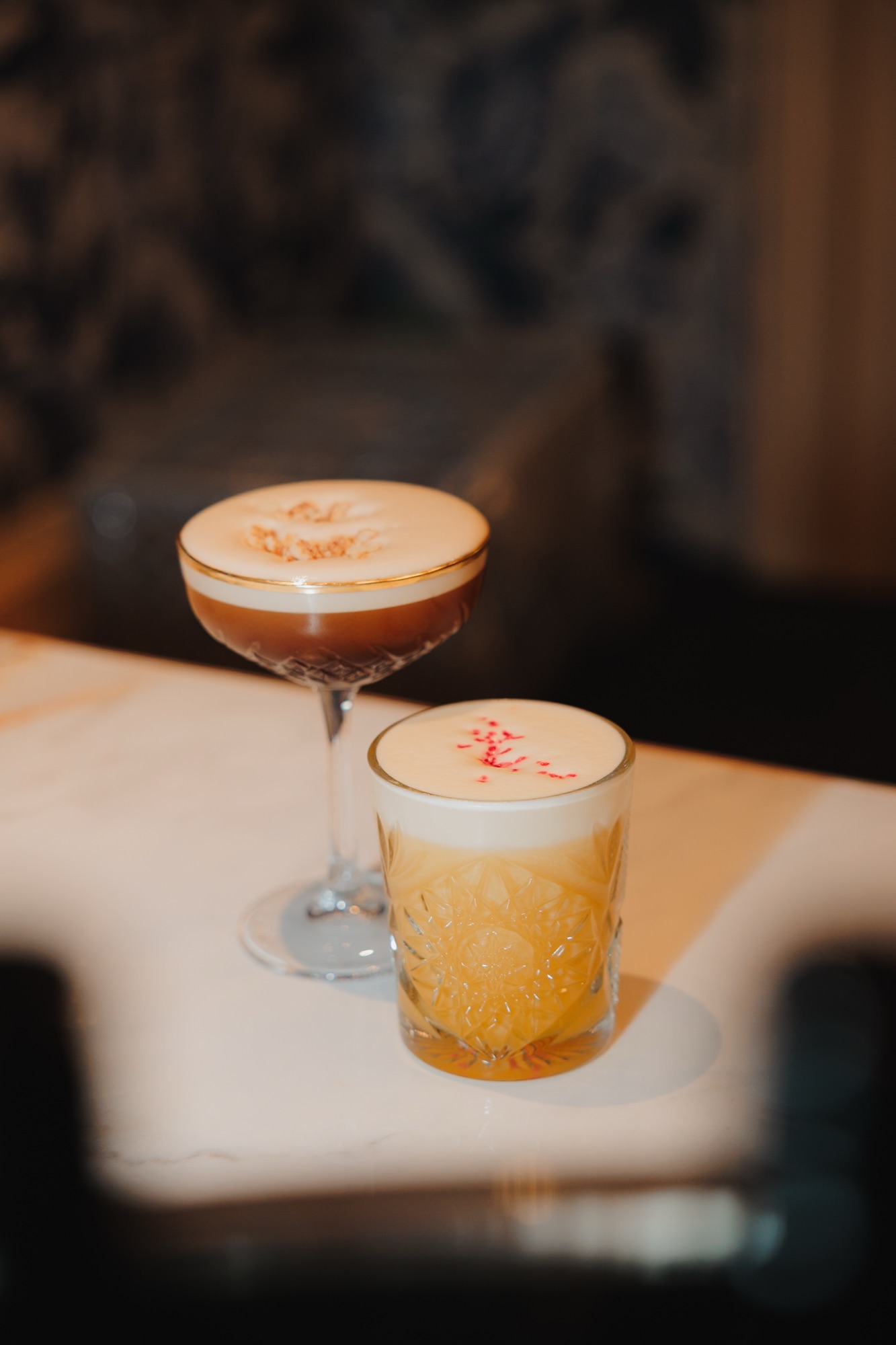 Twee afgewerkte cocktails van de workshop naast elkaar op de bar