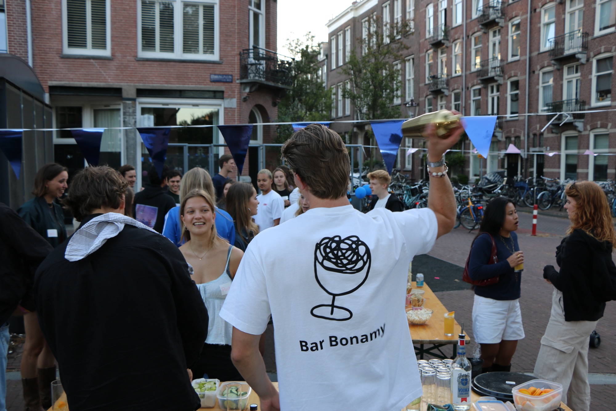 Bartender in Bar Bonamy-shirt shaket cocktails tijdens een straatfeest